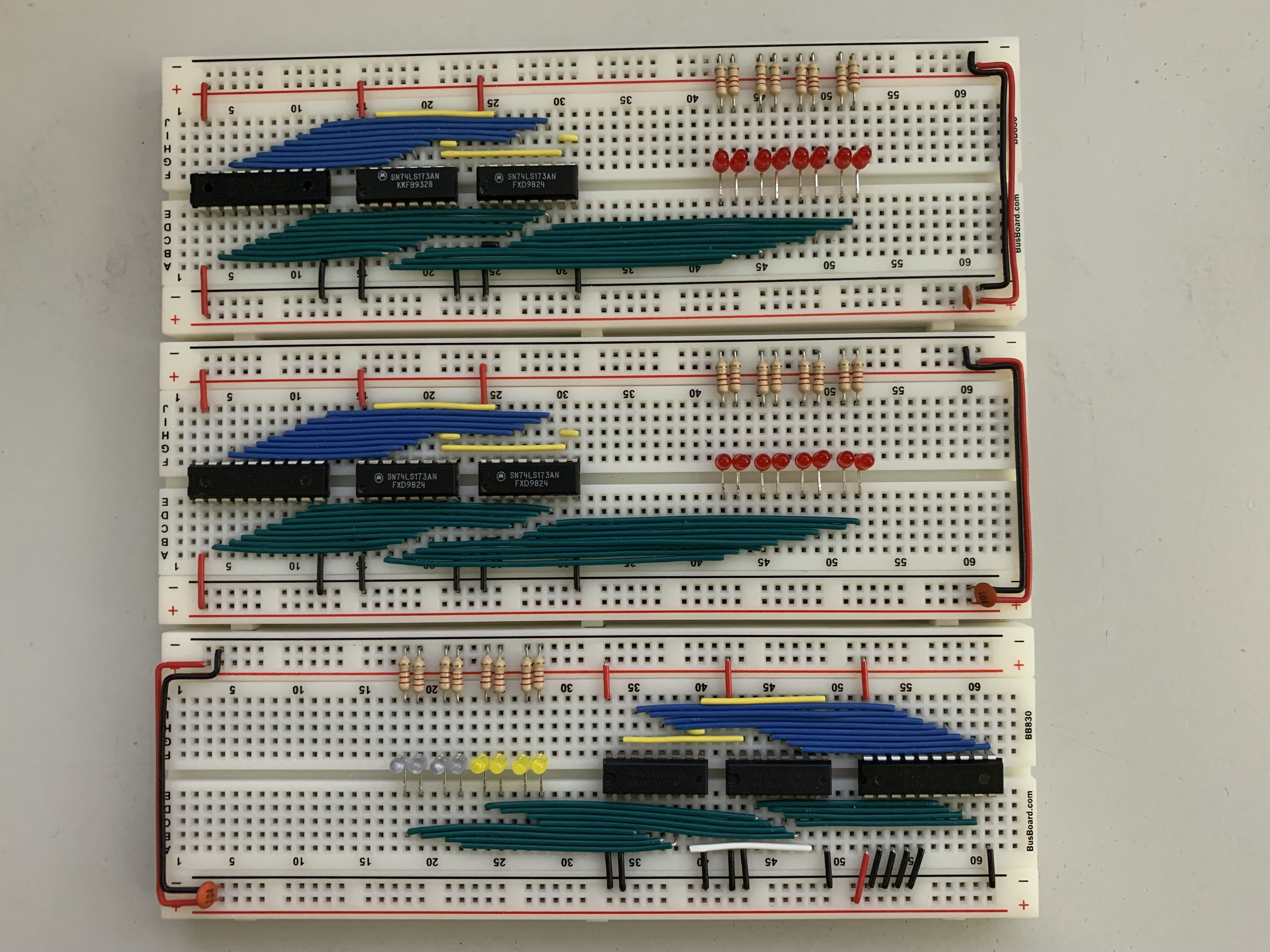 An image of 3 breadboards all populated in a similar way, except two have 8 red LEDs and one has 4 blue and 4 yellow LEDs. The blue and yellow breadboard also has its orientation flipped so the LEDs are on the left side instead of the right like the red boards.